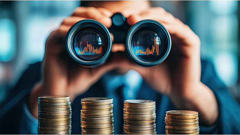 Man using binoculars with financial charts and stack of coins